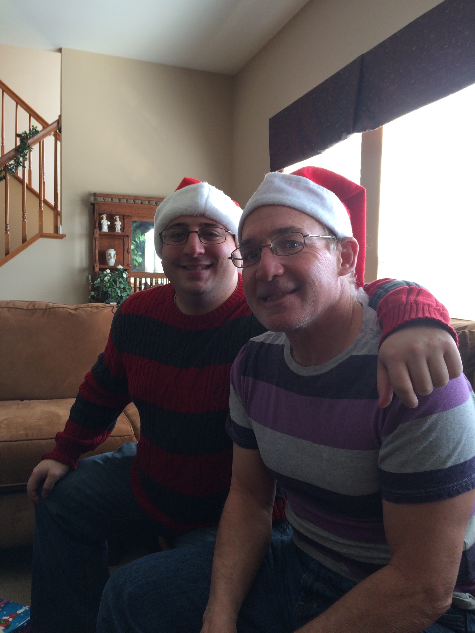 Father and son wearing Santa hats at Christmas