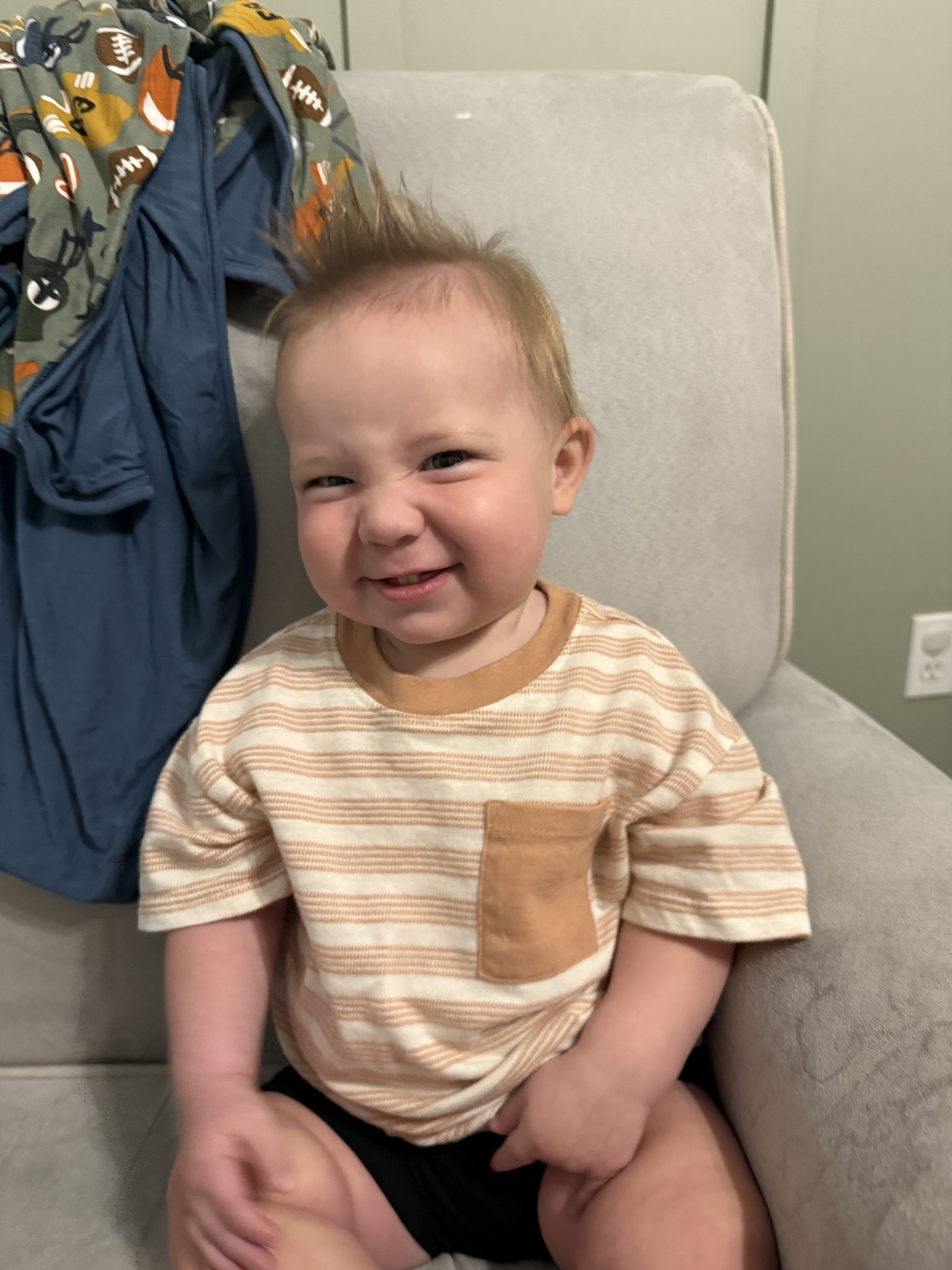 A smiling young child seated in a chair